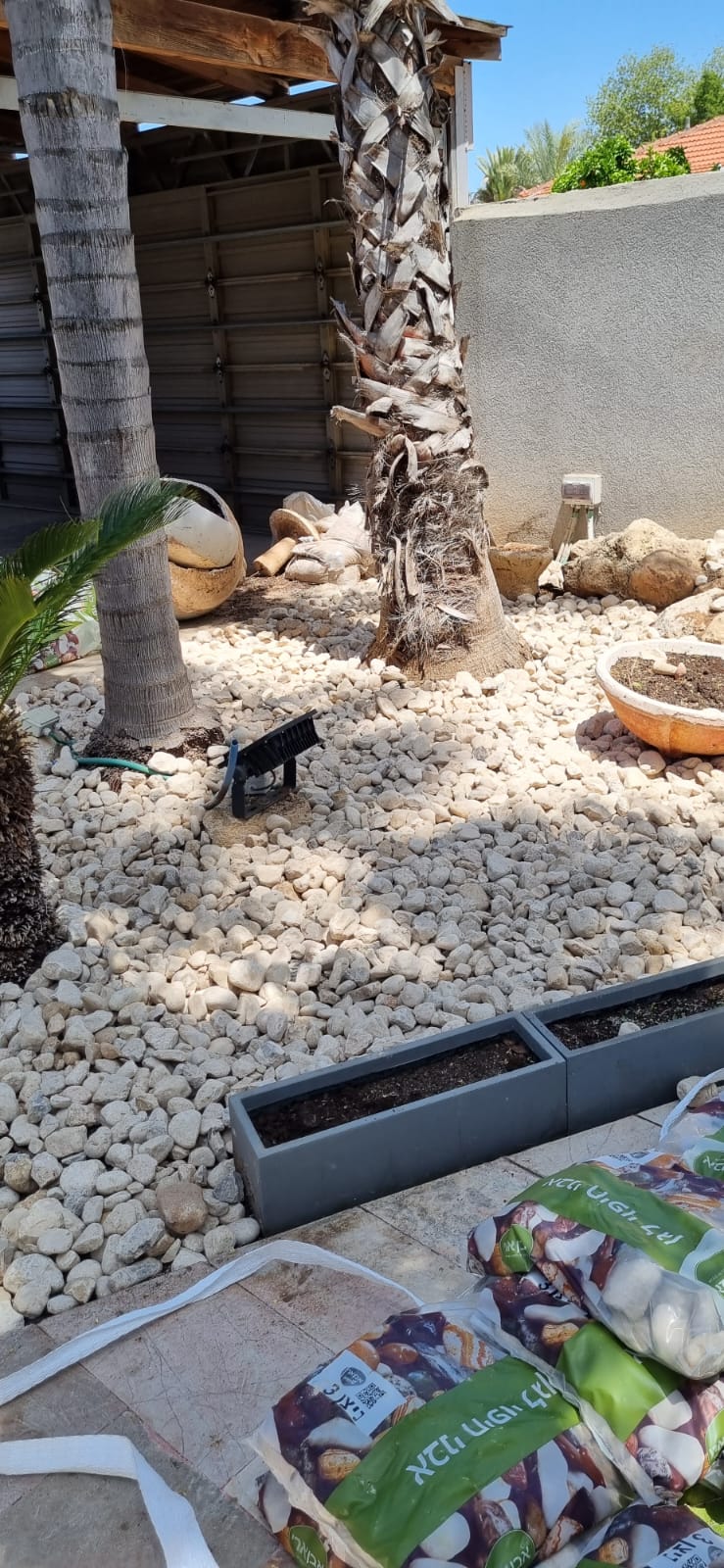 חיפוי חלוקי נחל וטוף ושתילות עם סידור שטח מאפס